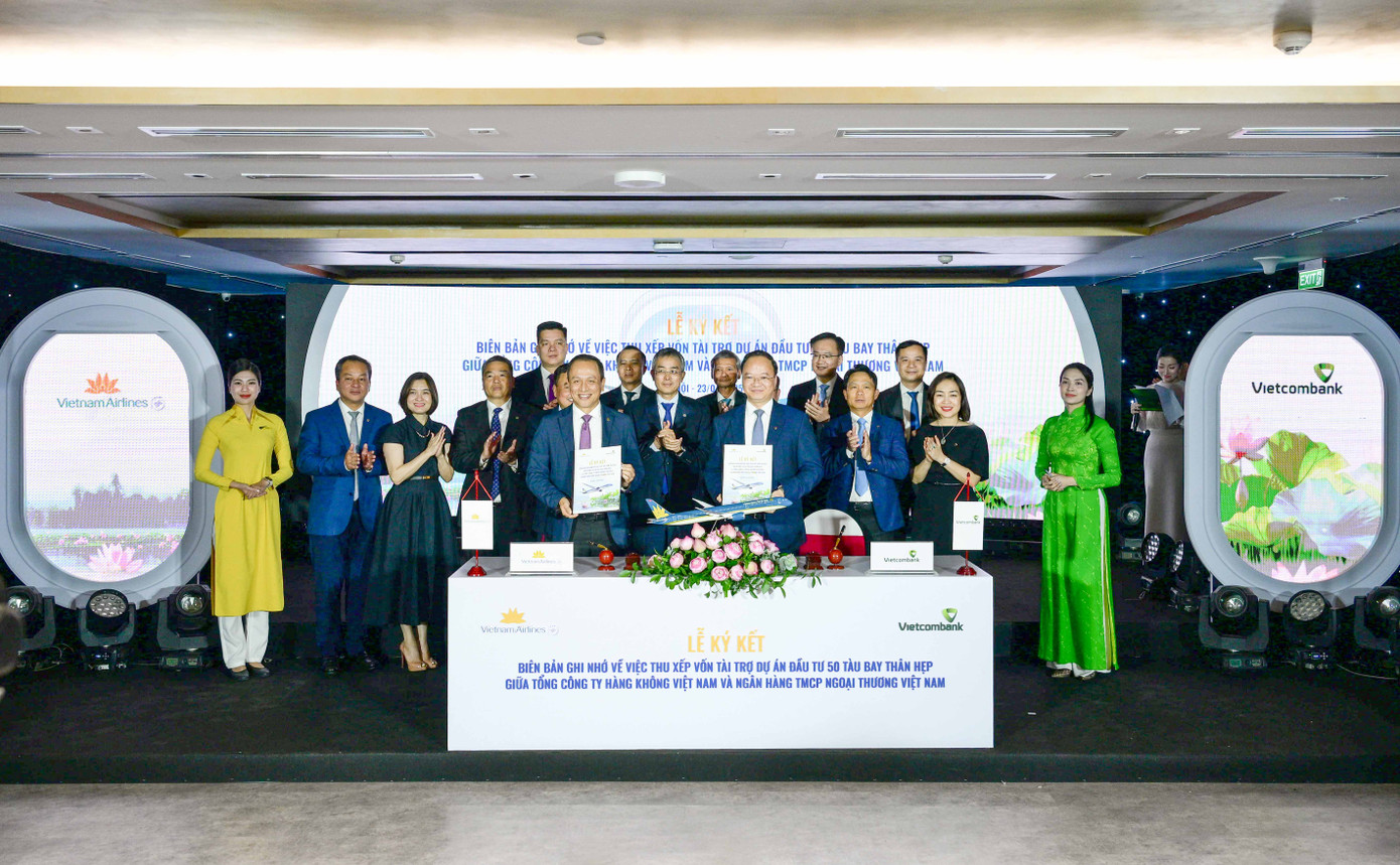 Ông Lê Quang Vinh - Thành viên HĐQT, Tổng Giám đốc Vietcombank (bên phải) và ông Lê Hồng Hà - Thành viên HĐQT kiêm Tổng Giám đốc Vietnam Airlines (bên trái) đại diện hai đơn vị hoàn thành nghi thức ký kết biên bản ghi nhớ trước sự chứng kiến của các đại biểu