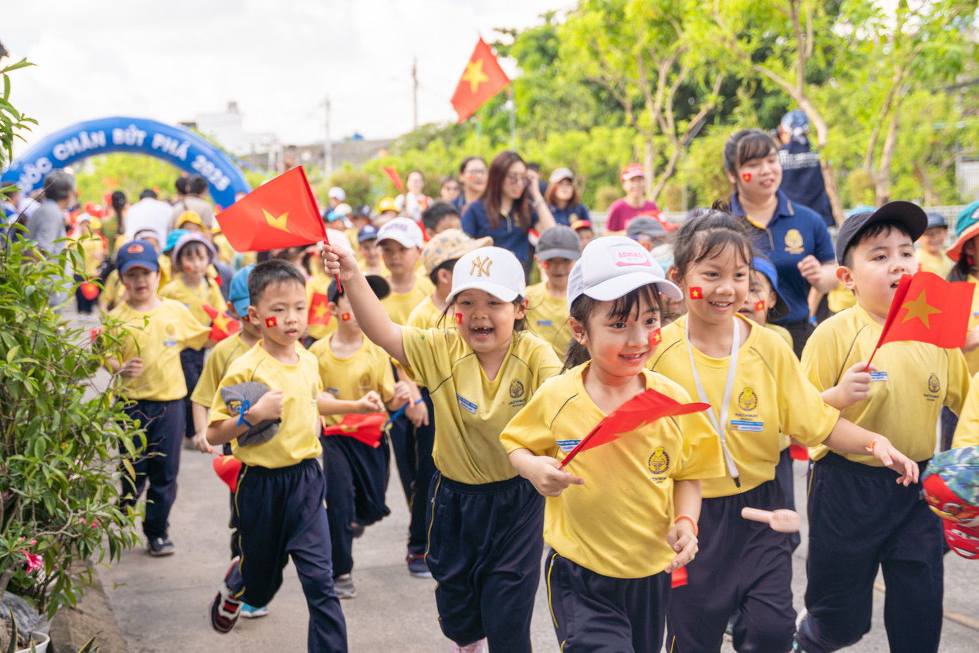Tập thể thầy cô cùng học sinh Pathway Tuệ Đức giơ cao lá cờ bước vào đường chạy