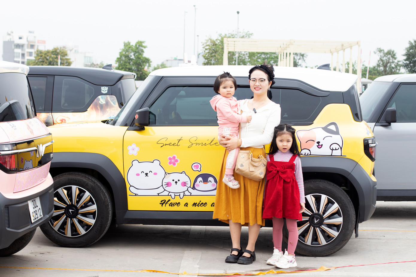 Chị Trần Thị Ngọc Hiệp cùng hai con bên xế yêu VF3 tham gia hoạt động xếp xe