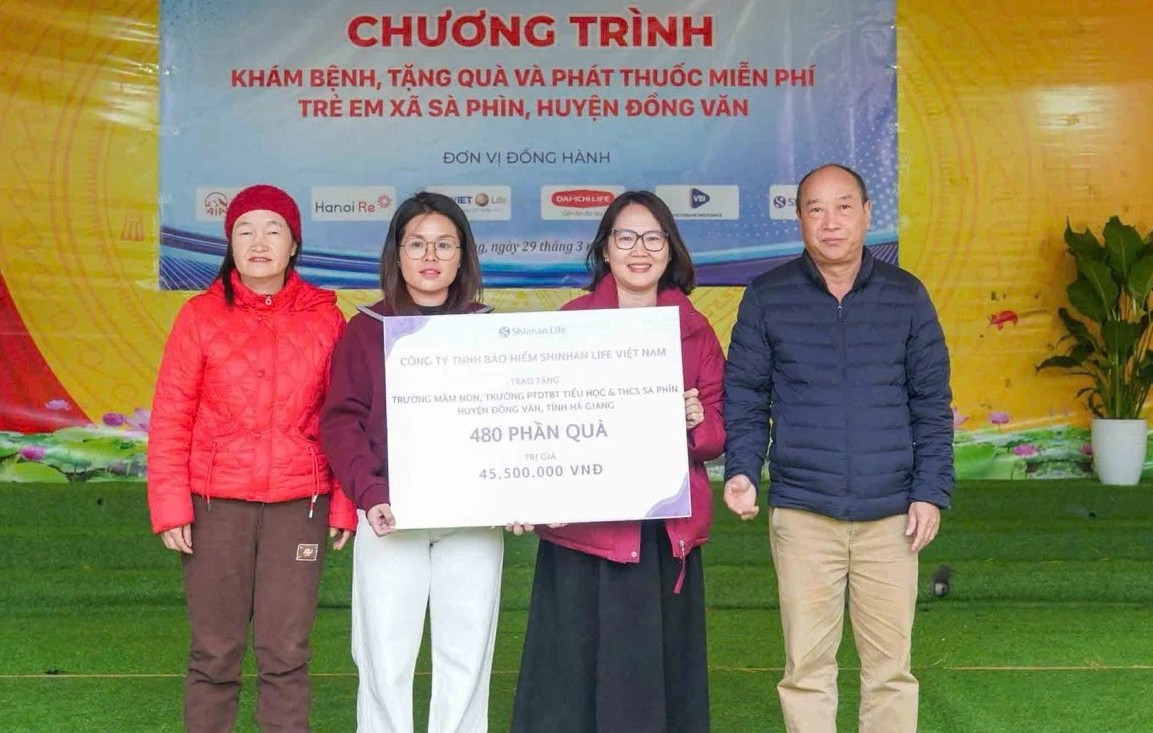 Đại diện Shinhan Life Việt Nam (thứ 2 từ phải qua) trao quà cho học sinh Trường Mầm non và Tiểu học Sà Phìn. Ảnh: Minh Minh