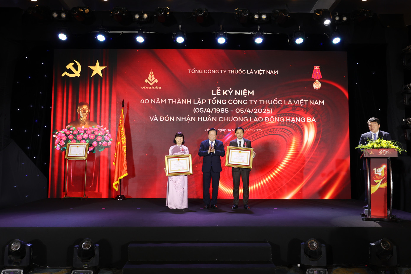 Ông Nguyễn Hoàng Anh, Phó Trưởng Ban Chính sách Chiến lược Trung ương trao Huân chương Lao động hạng Nhì cho ông Hồ Lê Nghĩa - Chủ tịch Hội đồng thành viên Tổng công ty Thuốc lá Việt Nam và bà Trần Thị Hoàng Mai - Phó Bí thư Thường trực Đảng uỷ Tổng công ty thuốc lá Việt Nam.