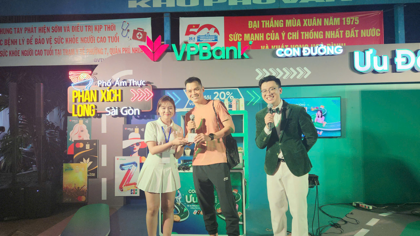 Anh Nguyễn Duy Minh Tâm (ở giữa) là khách hàng may mắn trúng Airpods tại phố Phan Xích Long