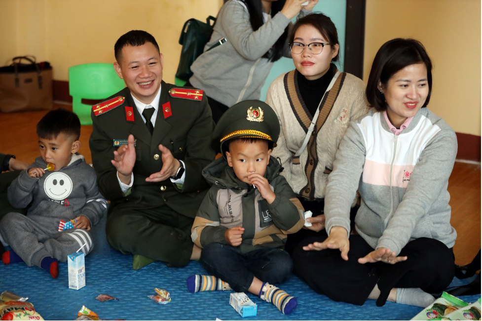 Cán bộ Cục Truyền thông CAND cùng với các cháu học sinh vùng sâu.