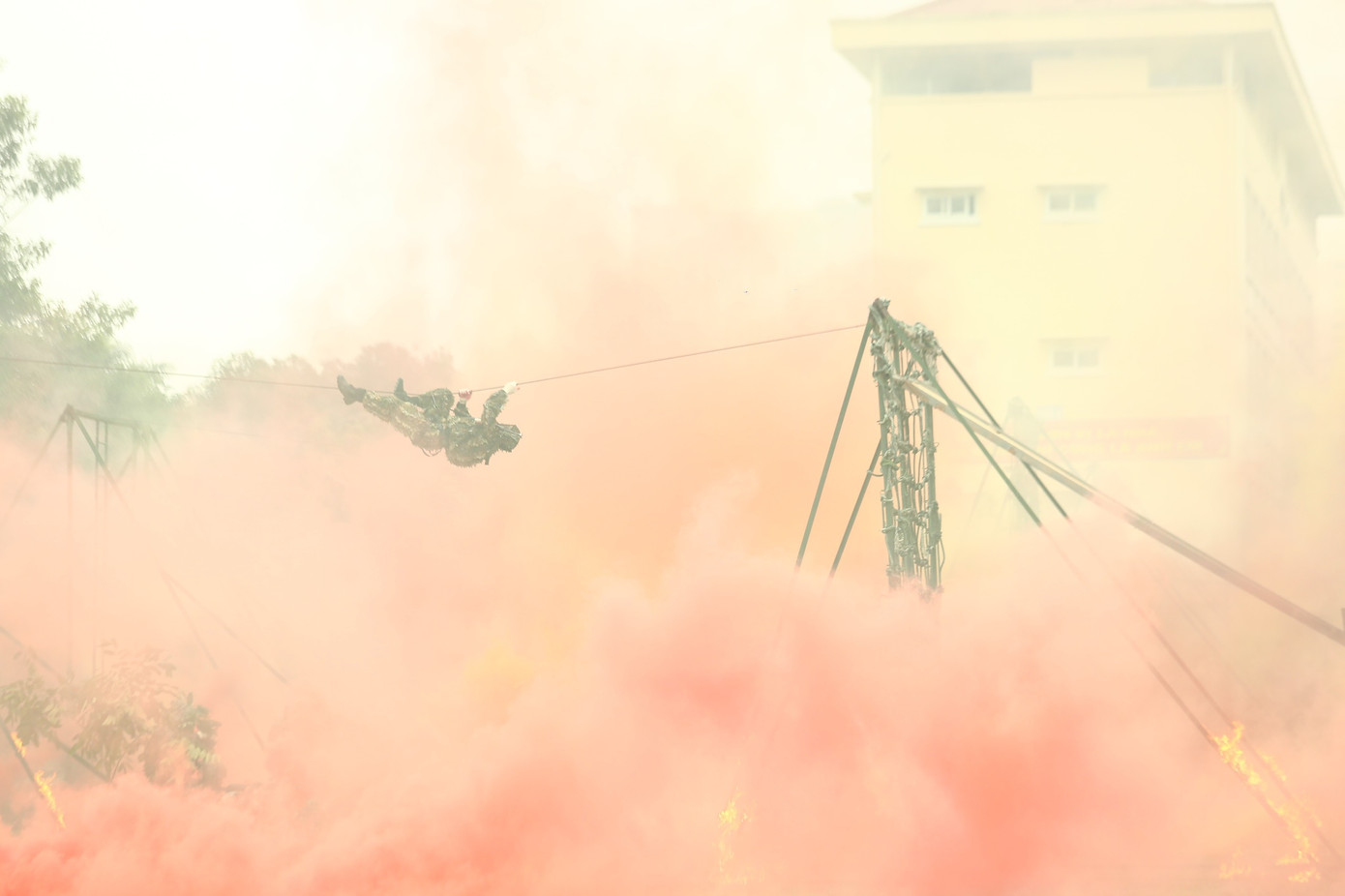 Cảnh sát đu dây vượt qua khói lửa.