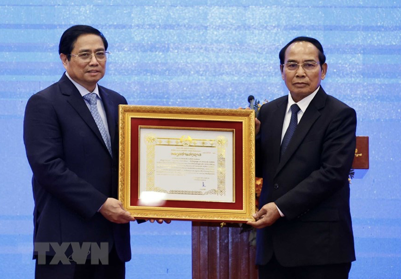 Thường trực Ban Bí thư, Phó Chủ tịch nước Lào Bounthong Chimany trao Huân chương Vàng Quốc gia tặng Thủ tướng Phạm Minh Chính. (Ảnh: TTXVN) Thường trực Ban Bí thư, Phó Chủ tịch nước Lào Bounthong Chimany trao Huân chương Vàng Quốc gia tặng Thủ tướng Phạm Minh Chính. (Ảnh: TTXVN)