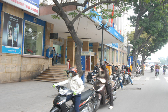 Nhiều xe máy lách luật bằng cách dừng đỗ dưới đường chờ người nhà vào Bưu điện giao dịch