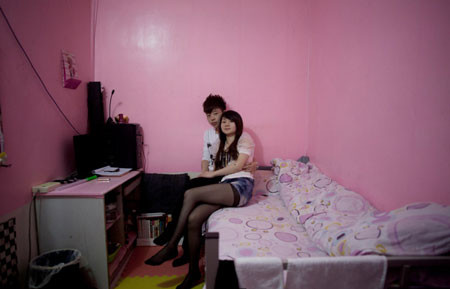 Jiang Yin, 24 tuổi, và Li Ying, 23 tuổi, trong căn phòng ngầm thuê chung của họ ở trung tâm Bắc Kinh ngày 14-5-2011. Jiang Ying là nữ tiếp viên quầy bar, còn Li Ying là công nhân văn phòng. Họ đã sống ở đây được một năm rưỡi. Họ tự trang trí phòng bằng giấy dán tường màu hồng