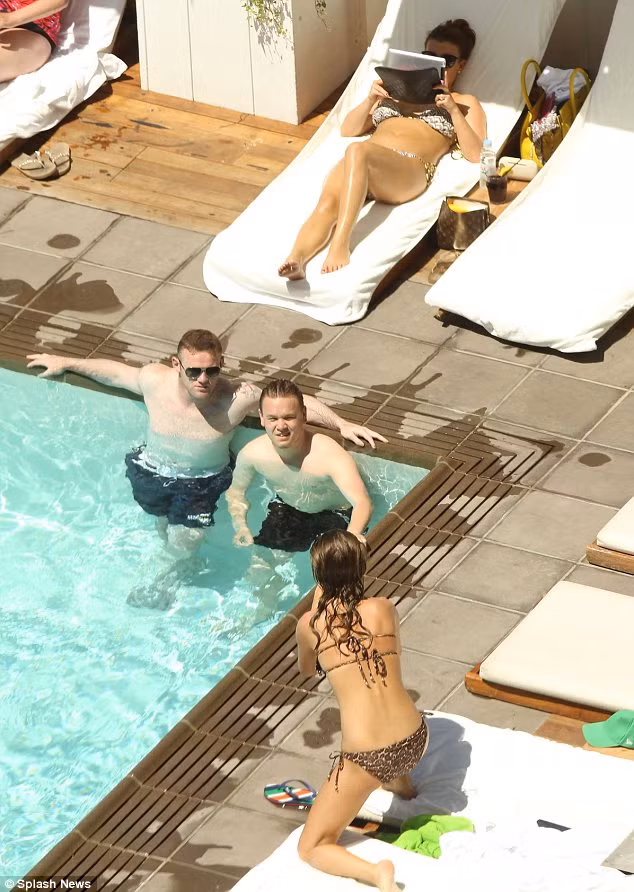 Rooney ngâm mình dưới bể bơi trong khi cô vợ Coleen nằm chơi iPad