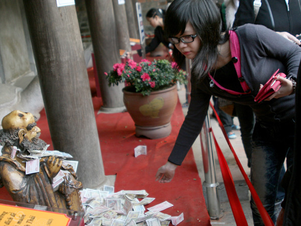 Tranh nhau thả tiền xuống các bình gốm