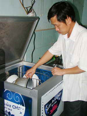 Anh Tân với chiếc máy rửa chén tự động Ảnh: Đ.M