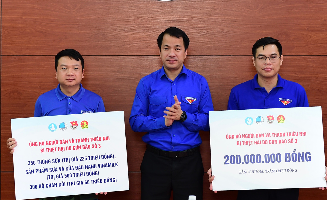 Anh Ngô Văn Cương trao biển tượng trưng nguồn lực hỗ trợ khắc phục hậu quả mưa lũ. Ảnh: Xuân Tùng