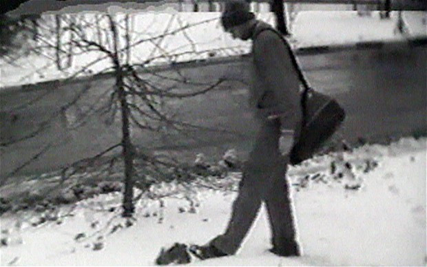 Một nam giới bị Nga cho là điệp viên Anh đi qua đi lại hòn đá giả (bên trong có thiết bị nhận và truyền tin)