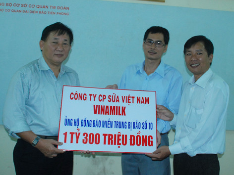 Ông Nguyễn Thanh Tú (trái) đại diện Công ty Vinamilk trao số tiền 1,3 tỷ đồng ủng hộ đồng bào bão lụt qua báo Tiền Phong