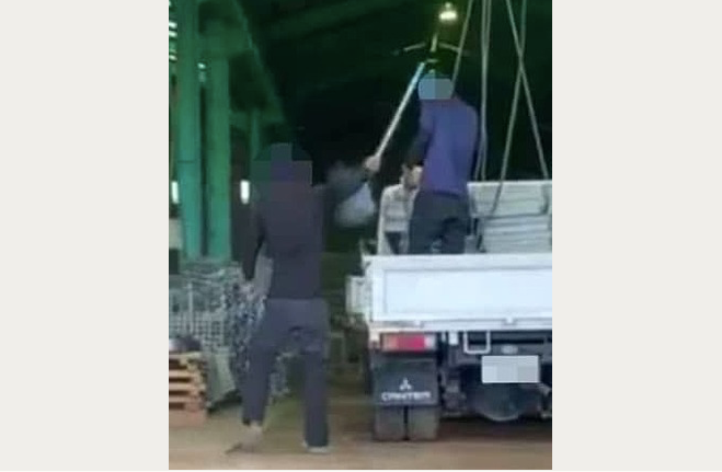 Hình ảnh cắt từ clip cho thấy thực tập sinh người Việt bị đồng nghiệp Nhật dùng chổi đánh vào đầu (Ảnh: Kyodo)