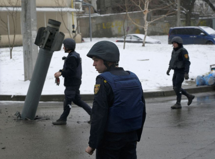 Lực lượng Ukraine đứng gần một rocket bị mắc kẹt ở Kharkiv ngày 25/2. (Ảnh: Reuters)