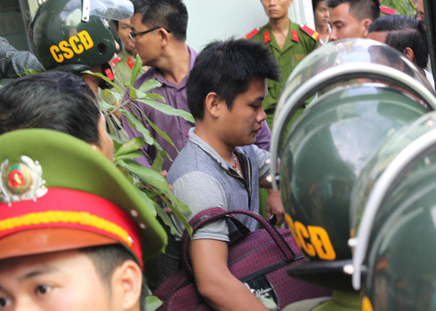 Một thành viên nhóm lừa đảo công nghệ cao ở Khánh Hòa bị bắt và dẫn giải ra xe. Ảnh: Việt Nữ - Vnexpress