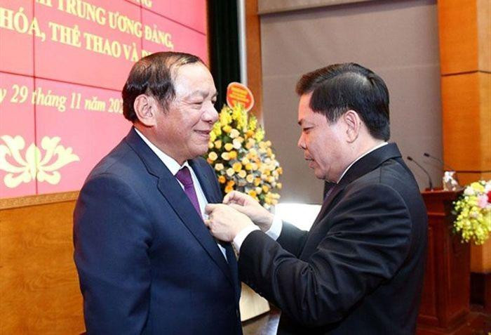 Bí thư Đảng uỷ Khối các cơ quan Trung ương Nguyễn Văn Thể trao Quyết định và gắn huy hiệu Đảng cho Bộ trưởng Nguyễn Văn Hùng. Ảnh: SGGP.