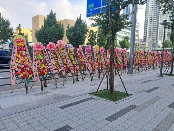 Hàng dài lẵng hoa yêu cầu Suga rời BTS đặt trước cổng trụ sở Hybe.