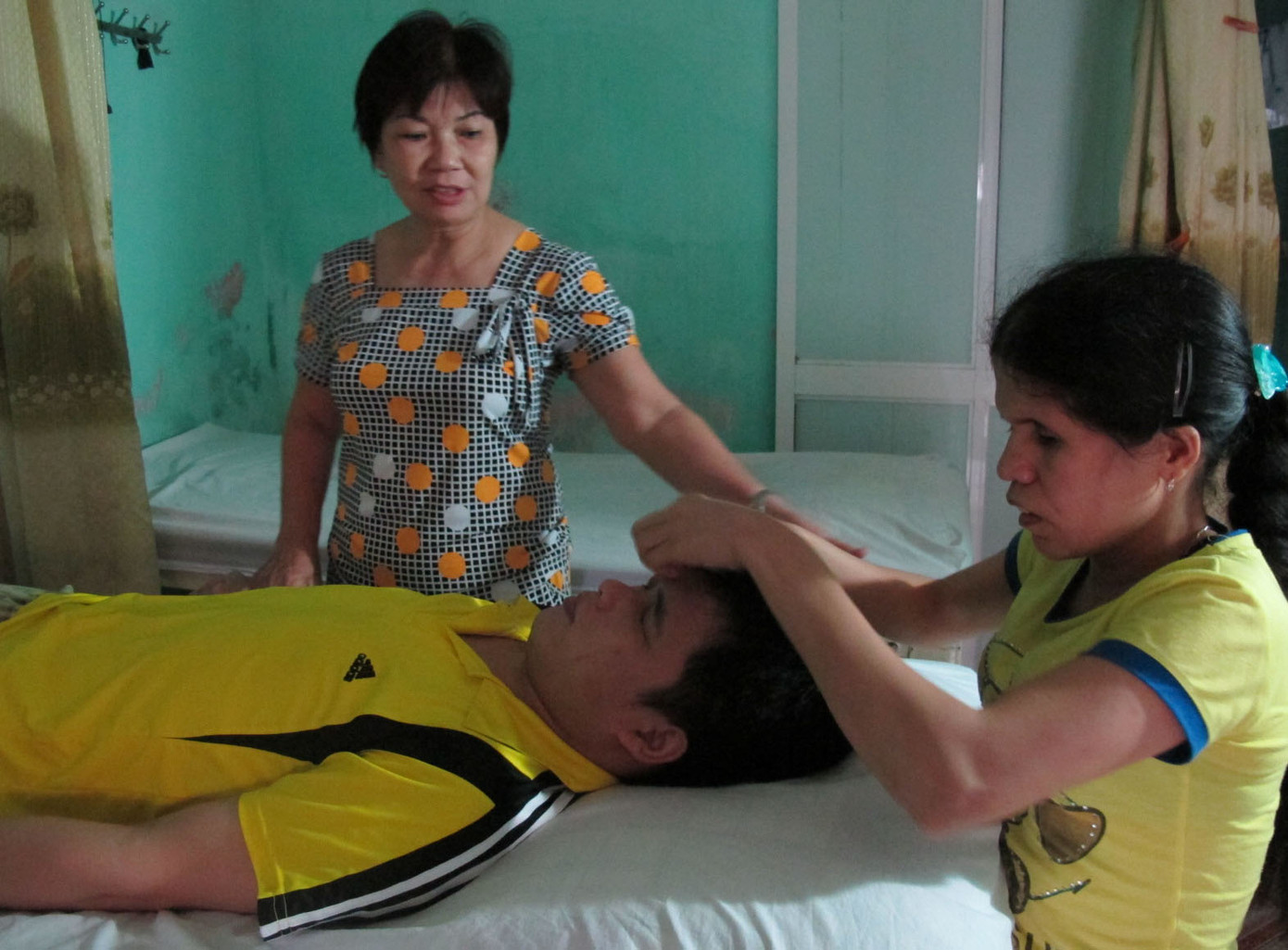 Bà Thúy hướng dẫn nhân viên mù bấm huyệt cho khách