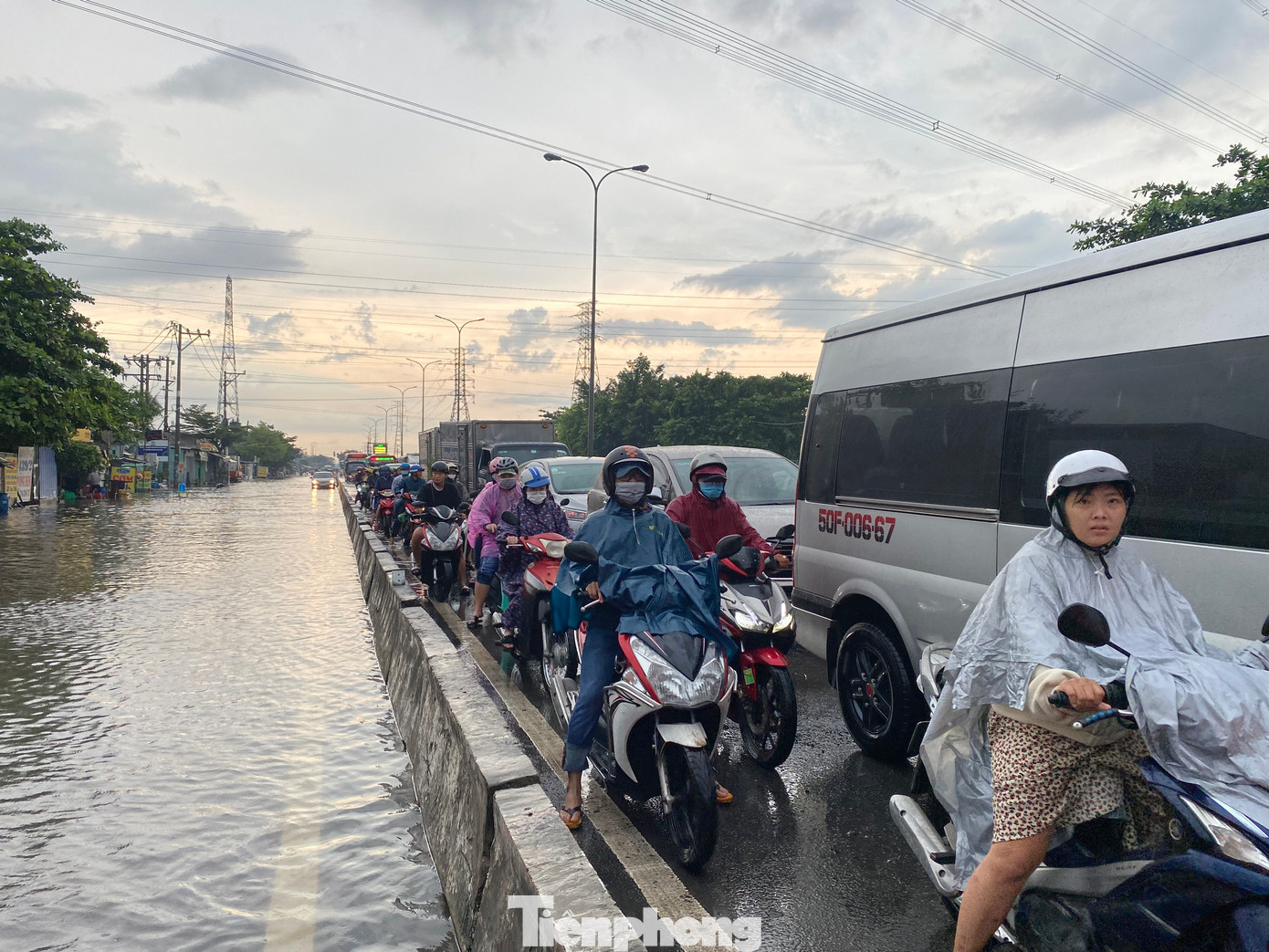 Nhiều người điều khiển xe máy di chuyển vào làn đường dành cho ô tô trên quốc lộ 1 để né những vị trí bị ngập sâu.