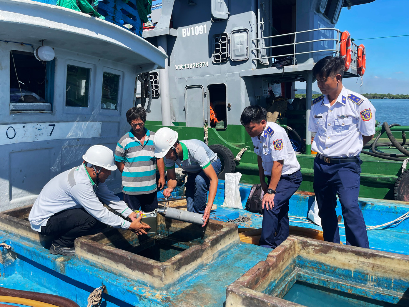 Cơ quan chức năng lấy mẫu hàng hóa trên tàu để giám định.