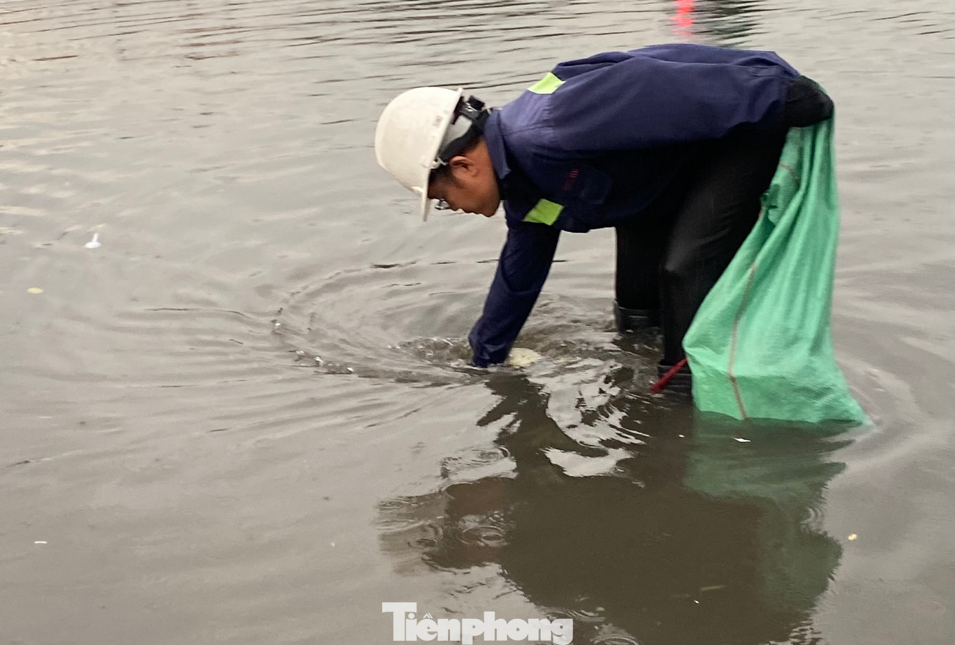 Công nhân túc trực vớt rác ở miệng cống để khơi thông dòng chảy.