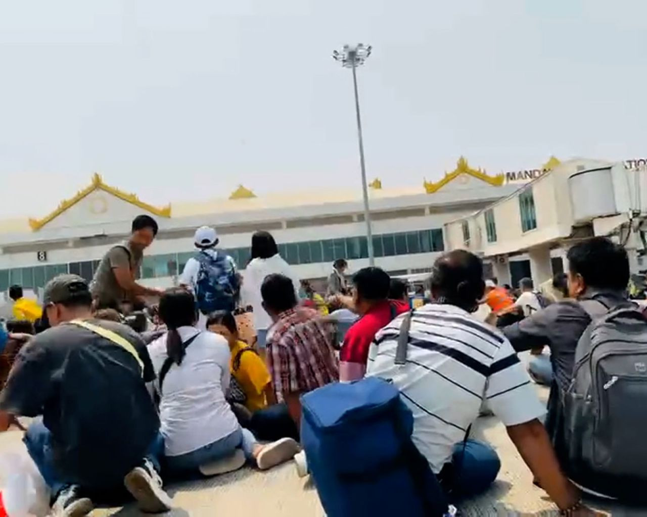 Hành khách tìm nơi ẩn náu tại sân bay Mandalay của Myanmar khi động đất xảy ra. Ảnh: X.