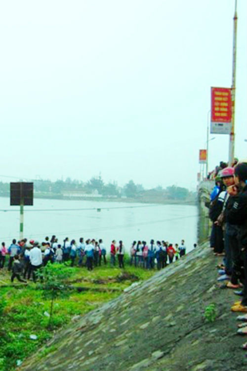 Rất đông người đứng hai bên bờ sông xem thợ lặn tìm kiếm nạn nhân.. Rất đông người đứng hai bên bờ sông xem thợ lặn tìm kiếm nạn nhân.