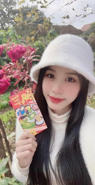 Á hậu Ngọc Hằng khoe lì xì trong ngày mùng 2 Tết. Cô chọn các trang phục gam màu trắng kín đáo, thanh lịch khi về quê đón Tết với gia đình.