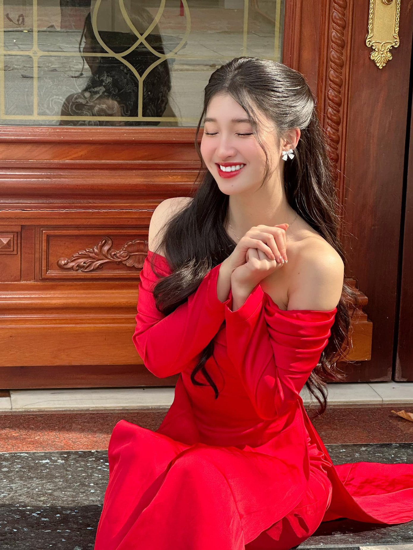 Á hậu Phương Nhi khoe nhan sắc ngọt ngào với bộ áo dài đỏ cách tân, trễ vai quyến rũ. Cô đón Tết ở Thanh Hóa cùng gia đình. Về quê đón Tết, Phương Nhi có dịp hội ngộ người bạn học cũ là Á hậu Trịnh Thùy Linh.