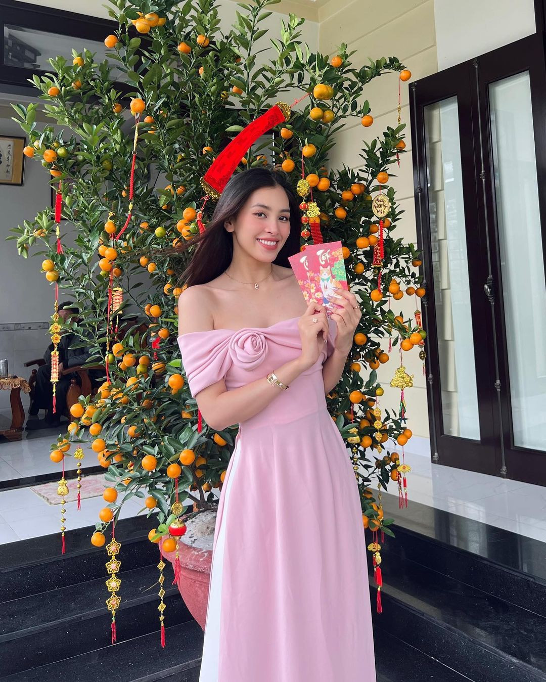 Hoa hậu Tiểu Vy chọn áo dài màu hồng trễ vai quyến rũ để mặc trong ngày đầu năm. Cô về đón Tết cùng gia đình ở Đà Nẵng. Do bận rộn công việc, sát ngày 30 Tết, Tiểu Vy mới về thăm nhà được.