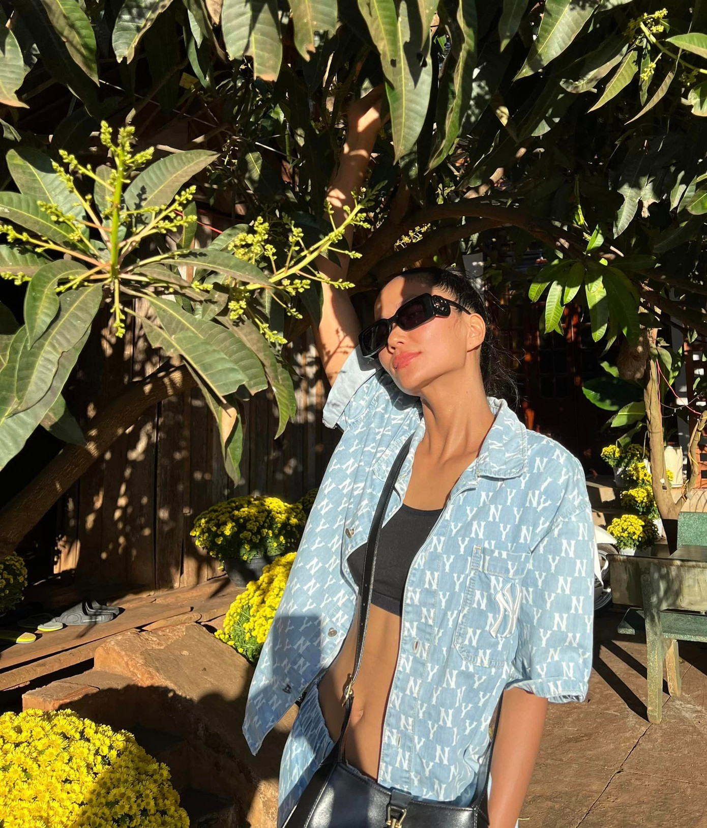 Hoa hậu H'Hen Niê trong vườn nhà ngày Tết. Cô gây chú ý khi khoe vòng eo "con kiến" săn chắc. H'Hen Niê được biết đến là người đẹp chăm tập thể thao nên có vóc dáng đáng ngưỡng mộ.