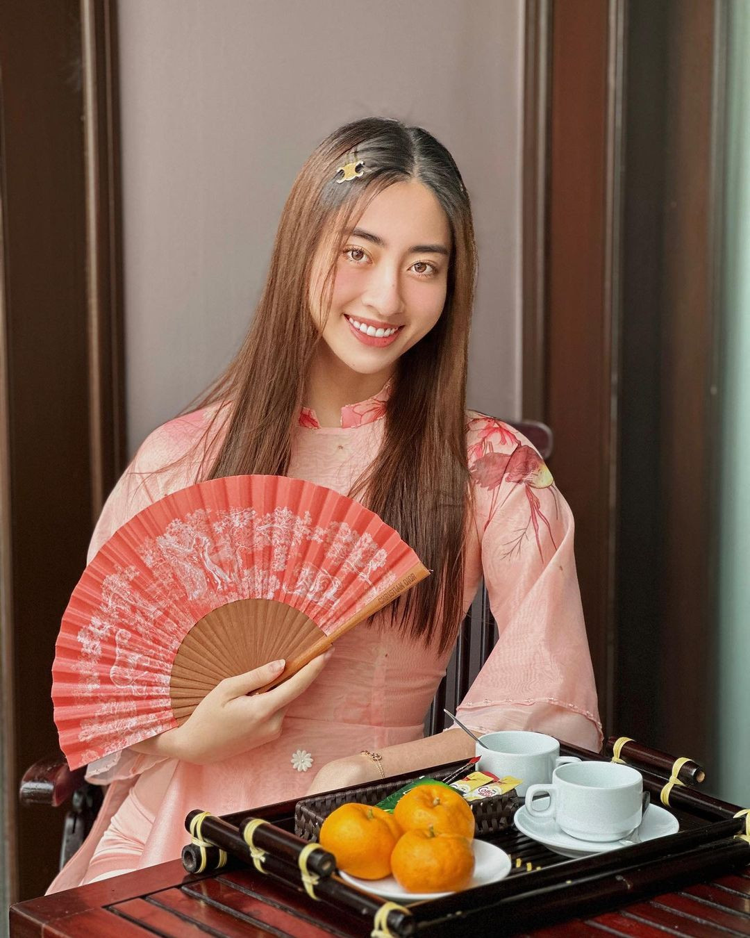 Hoa hậu Lương Thùy Linh diện áo dài khi đi thưởng trà ngày xuân cùng gia đình. Cô tận hưởng không khí thư giãn của những ngày đầu năm mới.