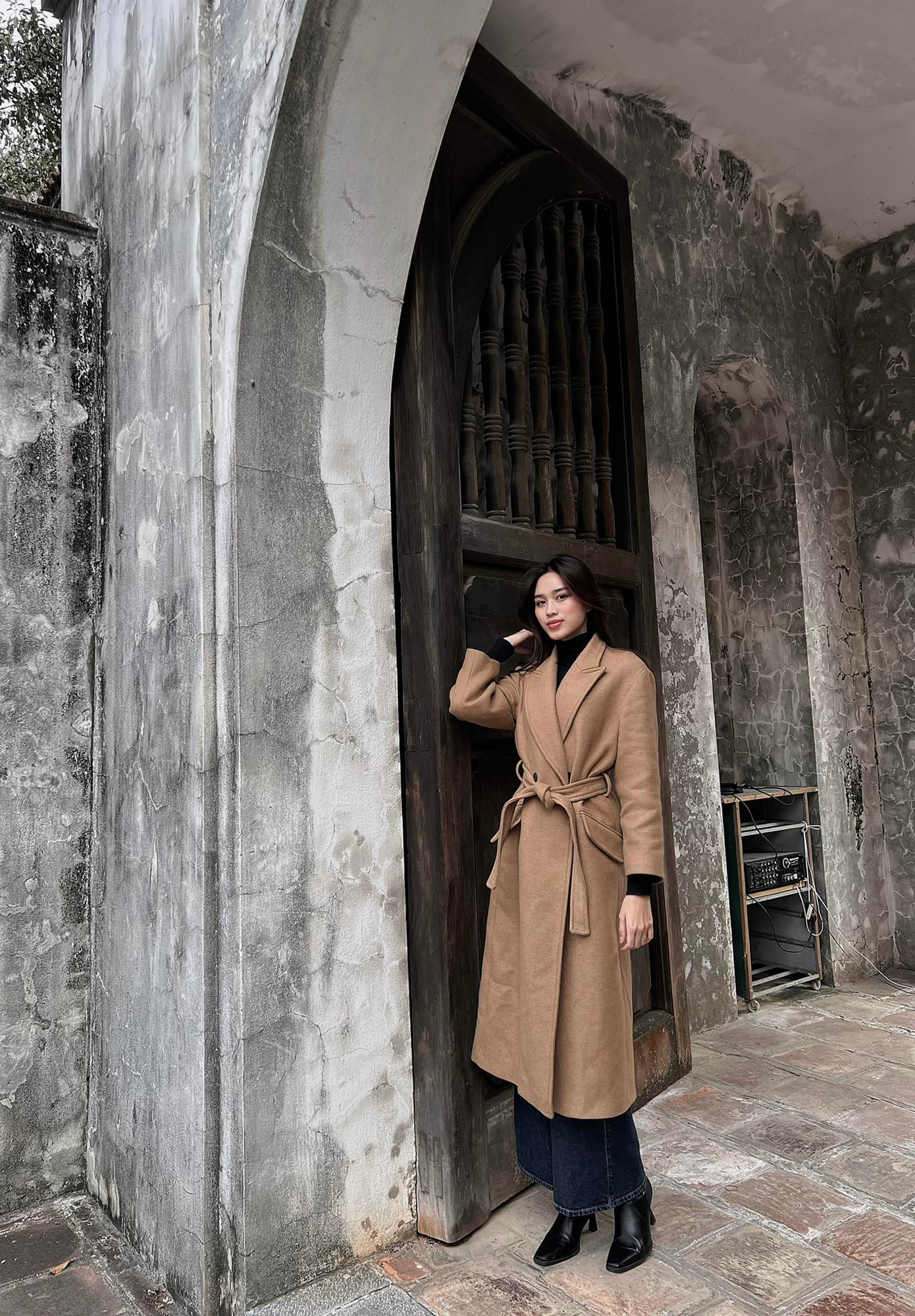 Hoa hậu Đỗ Thị Hà diện trang phục kín đáo, thanh lịch khi du xuân ngày mùng 3 Tết. Trời miền Bắc chuyển rét đậm nên người đẹp chọn áo măng-tô dáng dài kết hợp áo len cổ lọ để giữ ấm cơ thể.