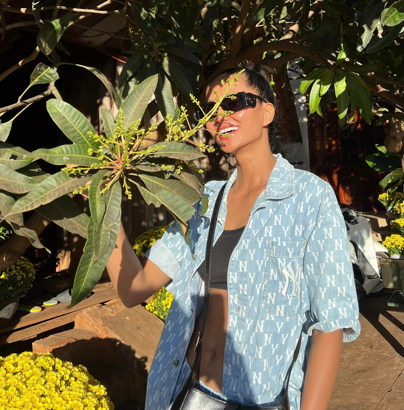 Hoa hậu H'Hen Niê trong vườn nhà ngày Tết. Cô gây chú ý khi khoe vòng eo "con kiến" săn chắc. H'Hen Niê được biết đến là người đẹp chăm tập thể thao nên có vóc dáng đáng ngưỡng mộ.