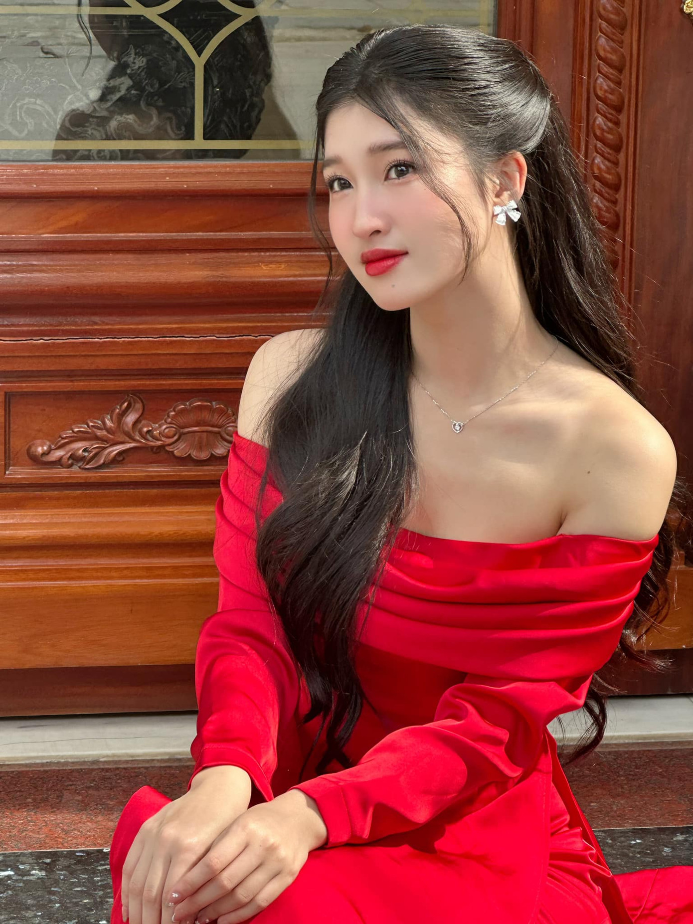 Á hậu Phương Nhi khoe nhan sắc ngọt ngào với bộ áo dài đỏ cách tân, trễ vai quyến rũ. Cô đón Tết ở Thanh Hóa cùng gia đình. Về quê đón Tết, Phương Nhi có dịp hội ngộ người bạn học cũ là Á hậu Trịnh Thùy Linh.