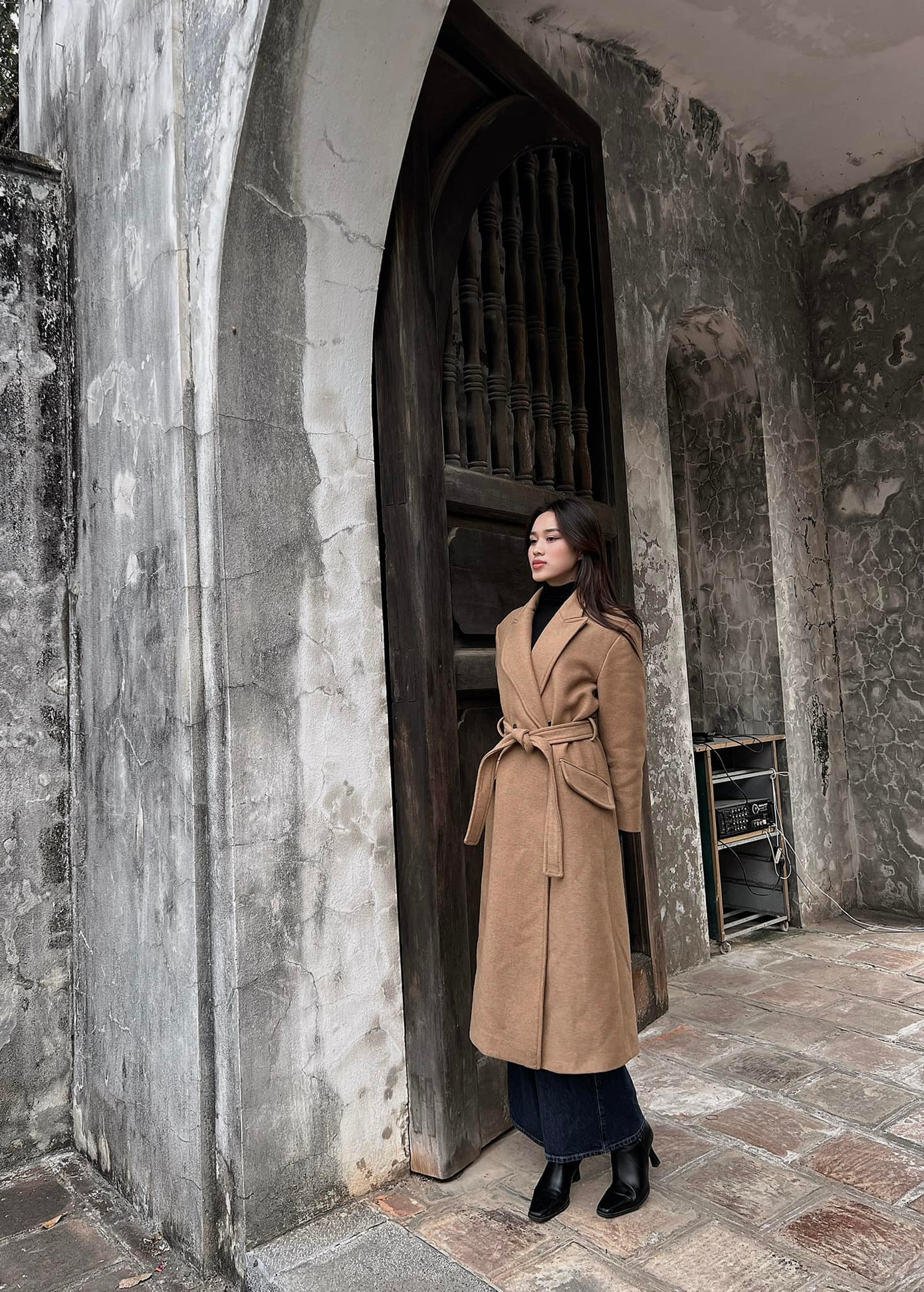 Hoa hậu Đỗ Thị Hà diện trang phục kín đáo, thanh lịch khi du xuân ngày mùng 3 Tết. Trời miền Bắc chuyển rét đậm nên người đẹp chọn áo măng-tô dáng dài kết hợp áo len cổ lọ để giữ ấm cơ thể.