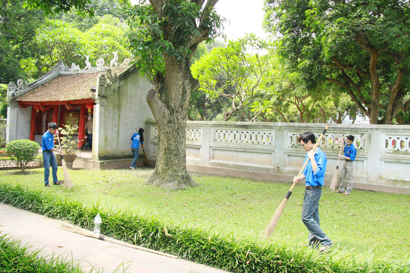 Một số sinh viên tình nguyện khác giúp việc vệ sinh cảnh quan trong khuôn viên Văn Miếu. Ảnh: Trường Phong