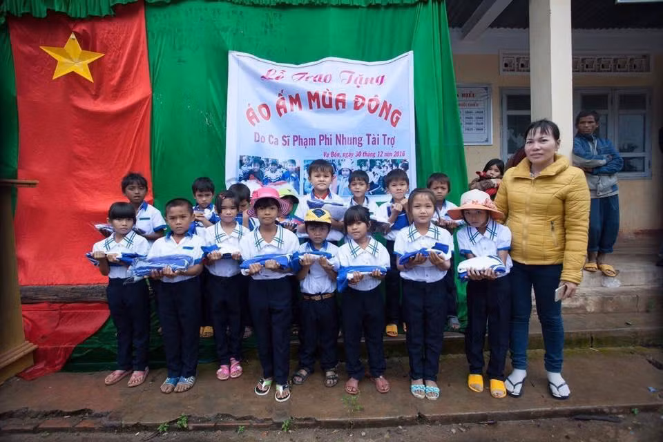 Học sinh miền cao hoàn cảnh khó khăn nhận áo ấm do ca sĩ Phi Nhung trao tặng.