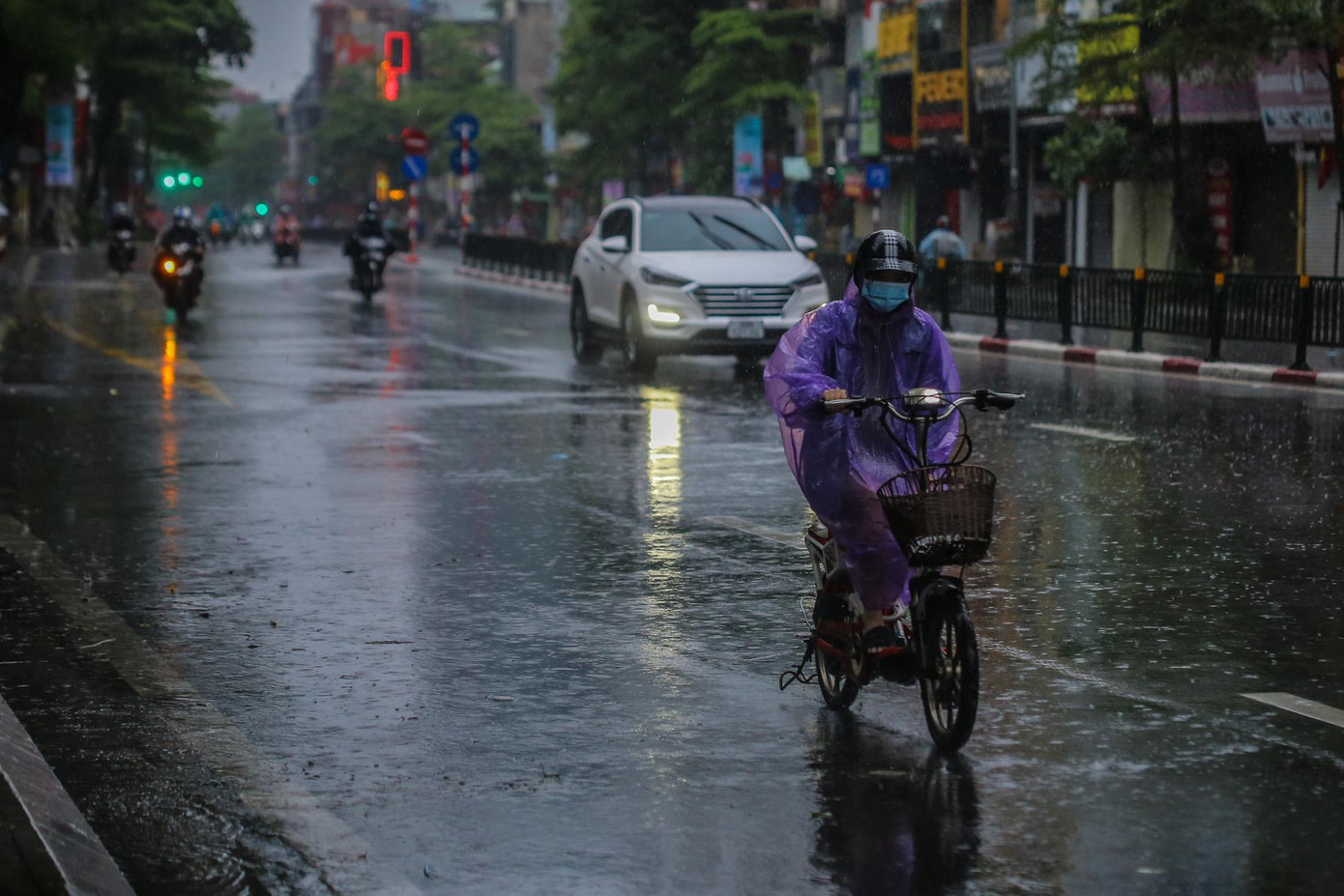 Áo mưa không chỉ giúp người đi đường tránh mưa mà còn giảm cái lạnh do nhiệt độ giảm thấp.