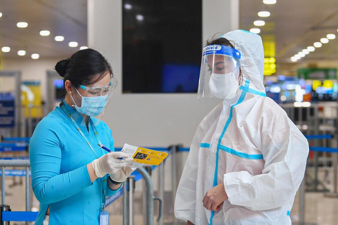 Nhân viên sân bay hướng dẫn một hành khách làm các thủ tục cần thiết trước khi lên máy bay đi TPHCM.