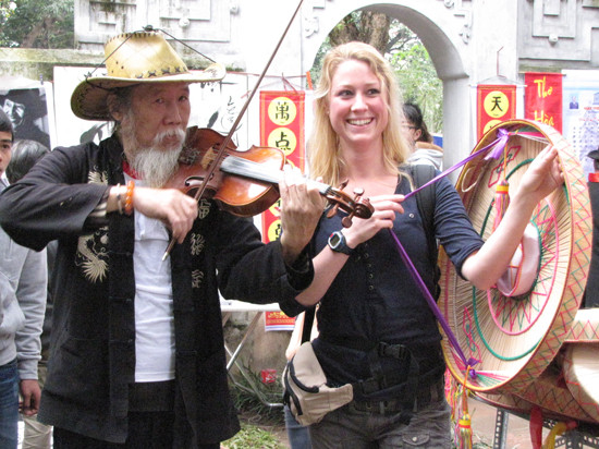 Một nữ du khách nước ngoài làm duyên với nói quai thao bên cạnh một nghệ sĩ Violon. Một nữ du khách nước ngoài làm duyên với nói quai thao bên cạnh một nghệ sĩ Violon
