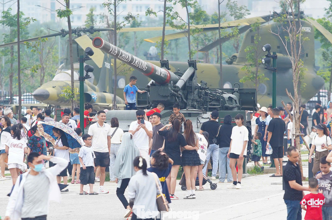 Từ sớm, khu vực sân, khu trưng bày ngoài trời của Bảo tàng Lịch sử Quân sự Việt Nam dần được du khách thập phương lấp kín. Dịp này, phần lớn du khách chọn mặc áo dài, áo đỏ sao vàng đến bảo tàng.