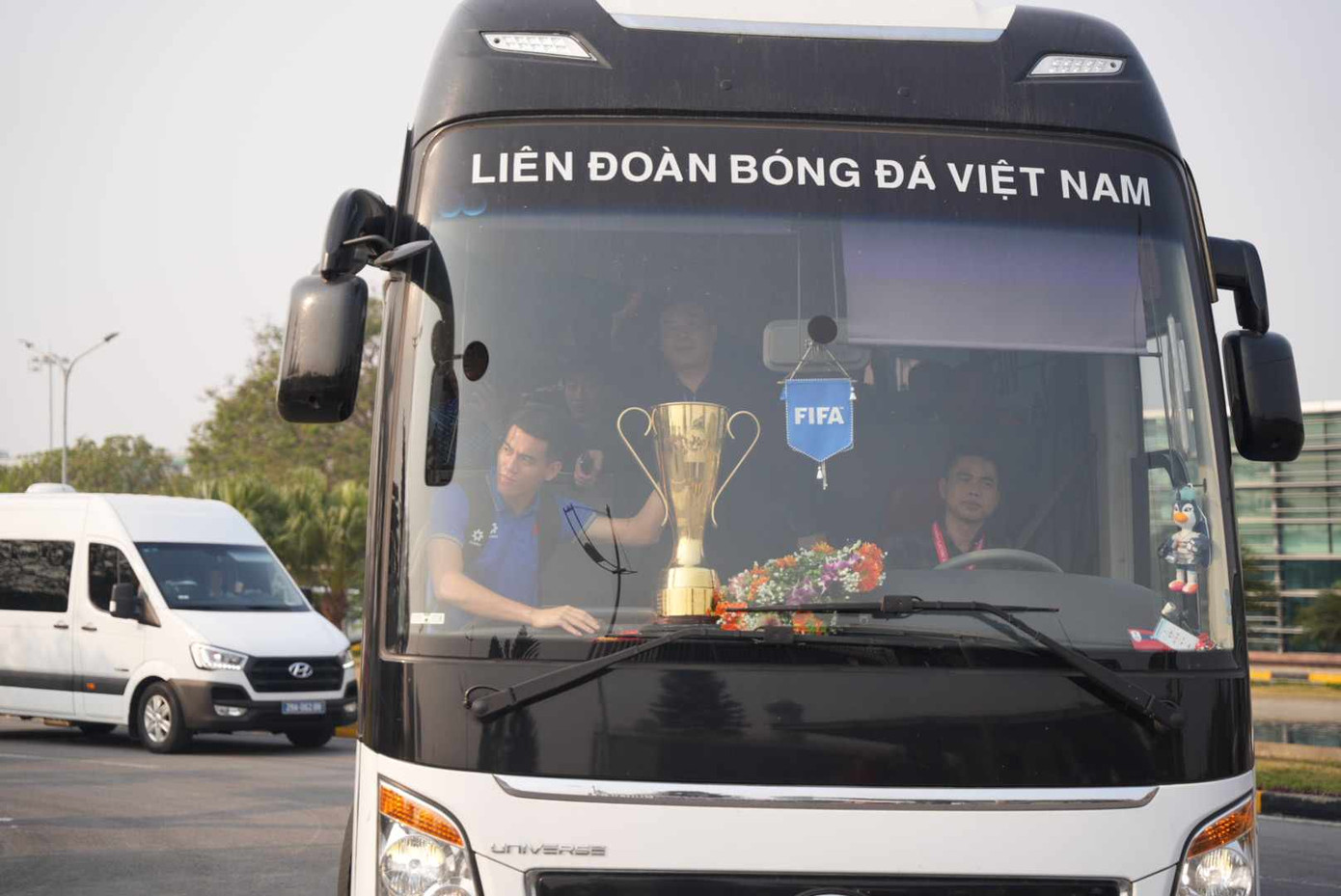 Tiến Linh cùng cúp vàng trên xe buýt chở về trung tâm Hà Nội.