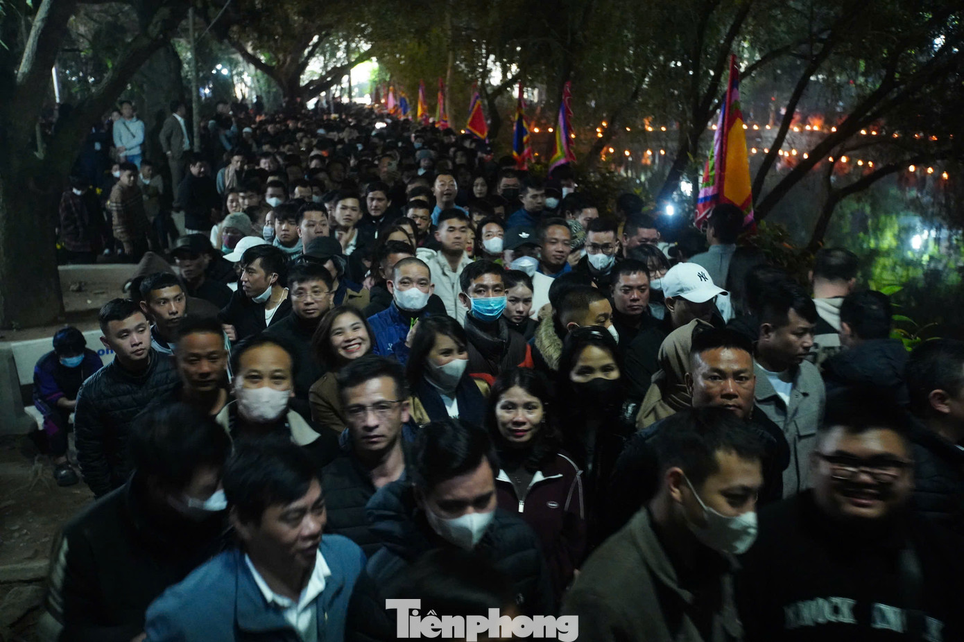 Lối vào sân đền cũng kín người. Lúc này, mưa bắt đầu đổ xuống nhưng không ngăn được sự thành tâm của người dân hướng về Đức Thánh Trần.