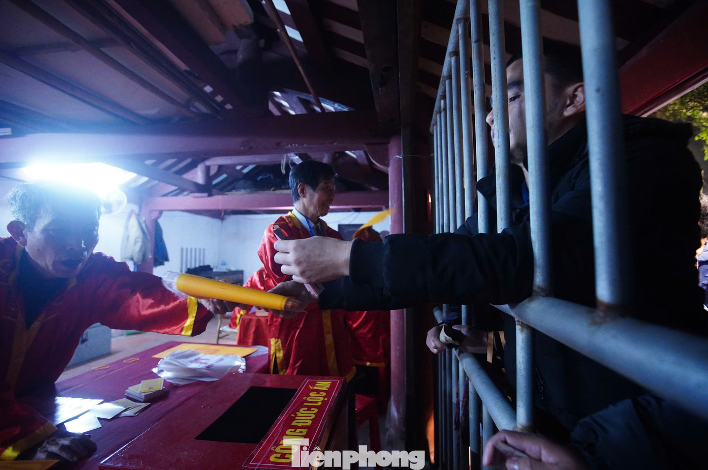 Những người phụ trách phát ấn làm việc không ngơi tay khi lượng khách đổ về đây tăng cao. Từ 5h-5h40 sáng 12/2 (ngày 15 tháng Giêng) ấn đã được phát hết cho lượt khách đầu tiên. Phần lớn đây là khách đã đợi cả đêm ngoài cổng đền.