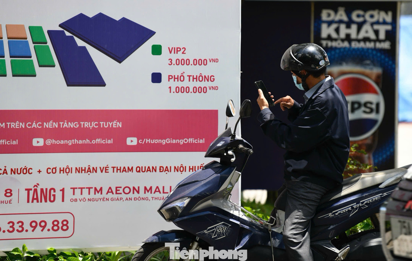 Khán giả quan tâm, chụp ảnh lại pano, áp phích trên đường để ghi lại thông tin về sự kiện.