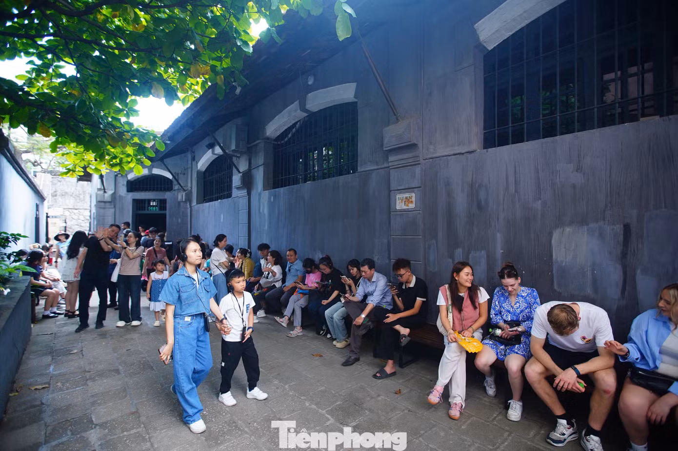 Hàng dài du khách nghỉ ngơi, đợi chờ trong khuôn viên di tích. Một số du khách phải đợi không gian trong nhà tù vãn khách mới có thể vào tham quan.