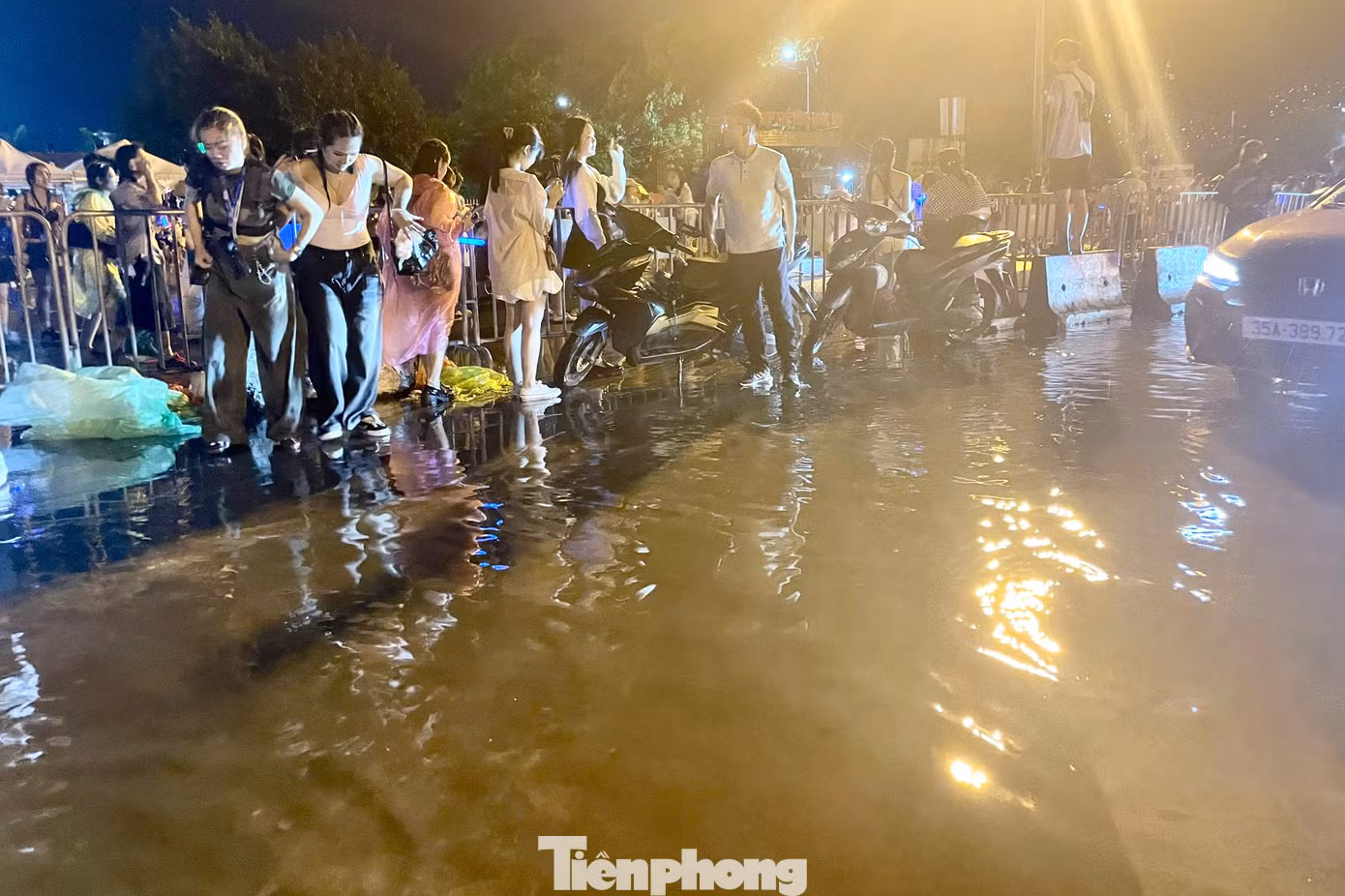 Sau cơn mưa lớn, một số điểm trước cổng SVĐ Mỹ Đình lõng bõng nước. Mức độ ngập ở khu vực này không cao, nhưng vẫn khiến nhiều người gặp khó khăn khi di chuyển, tìm kiếm phương tiện về nhà.