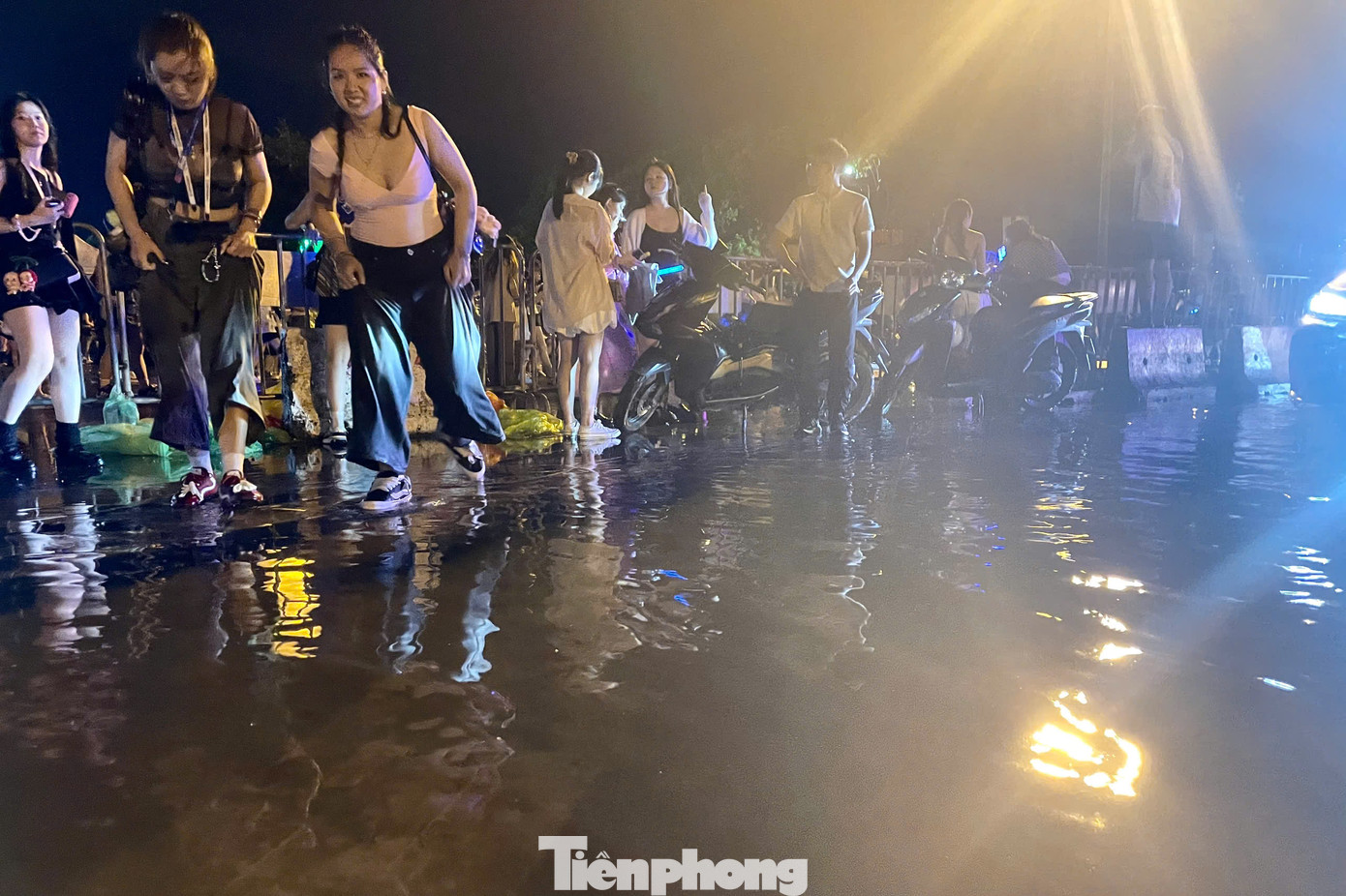 Sau cơn mưa lớn, một số điểm trước cổng SVĐ Mỹ Đình lõng bõng nước. Mức độ ngập ở khu vực này không cao, nhưng vẫn khiến nhiều người gặp khó khăn khi di chuyển, tìm kiếm phương tiện về nhà.